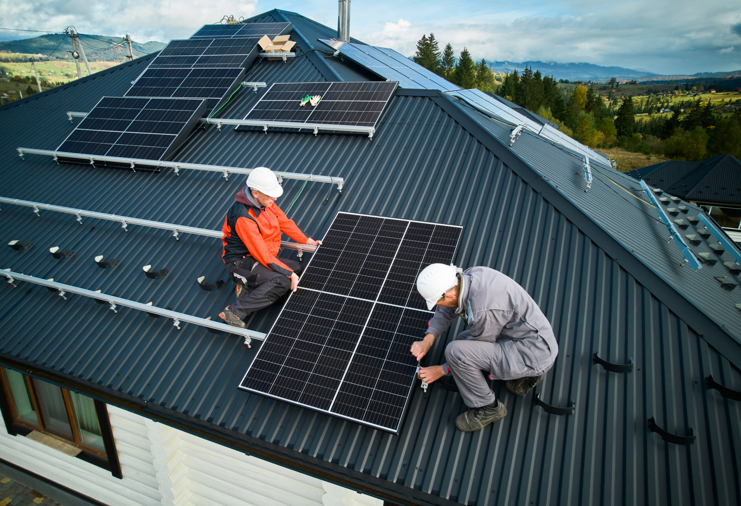 2 Techniker bringen ein Solarpaneel an Schienen an